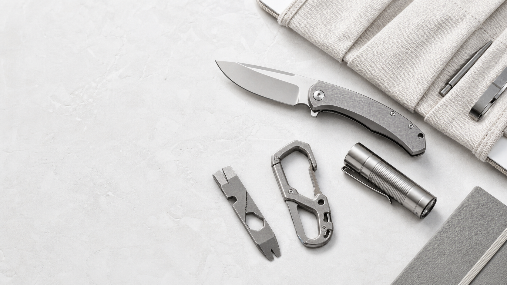 Compact EDC tools on a white stone surface